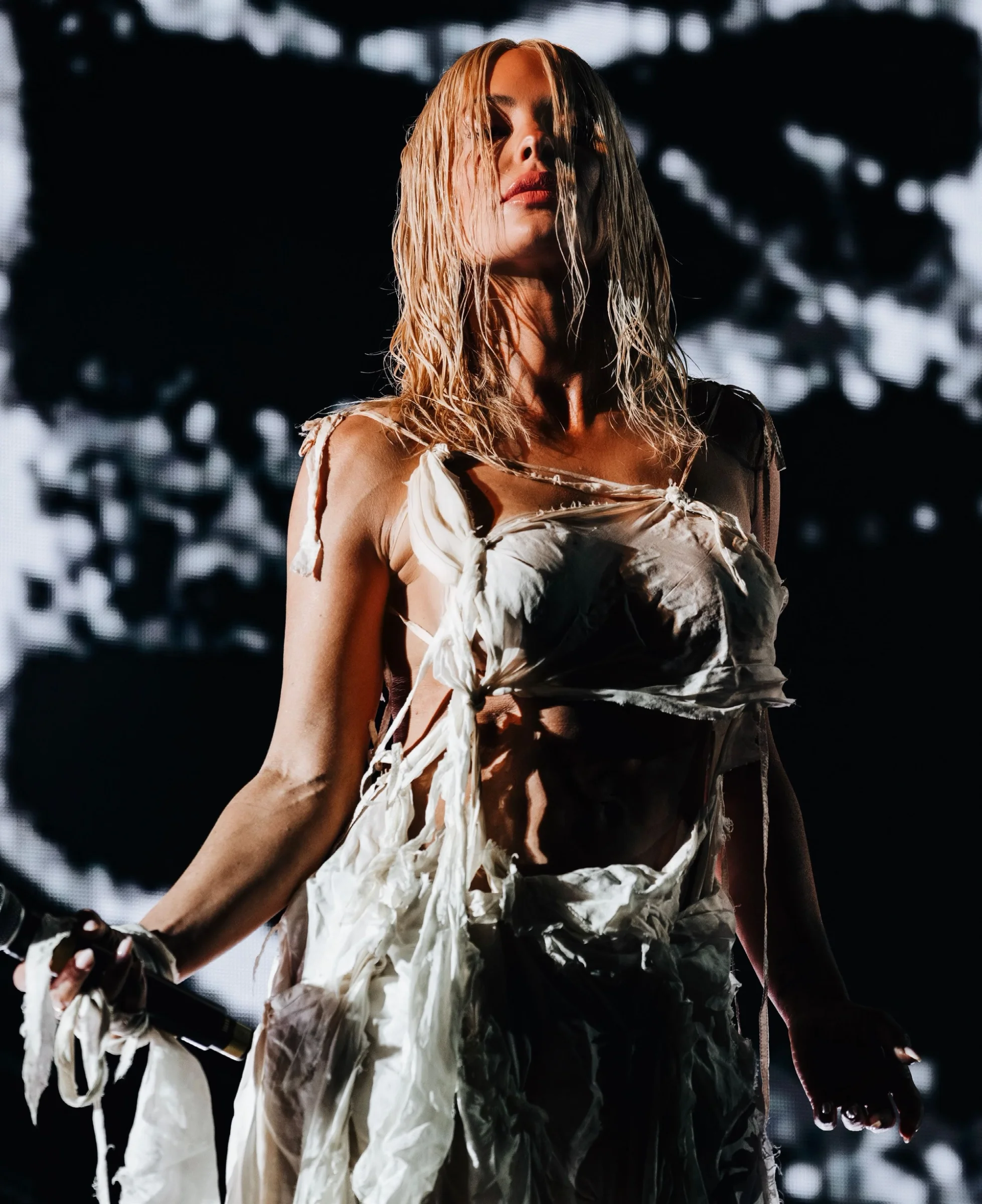 Aimée Sophia performing Dune on stage in a white dress